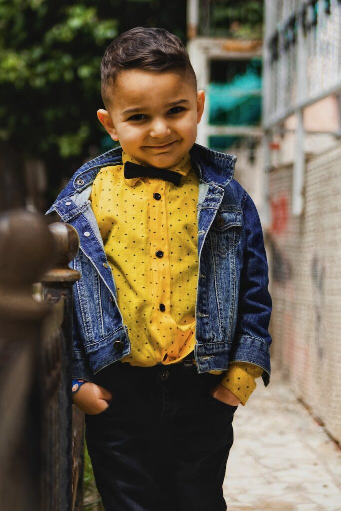 adorable little boy in an elegant shirt with bow tie and a denim jacket