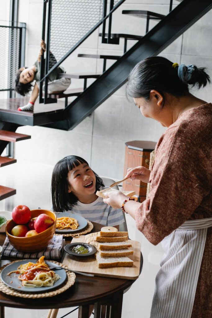 happy little girl looking at grandmother during lunch