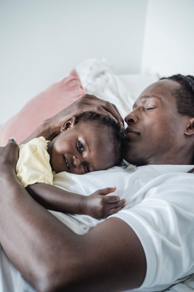 portrait of an affectionate father and baby daughter lying down